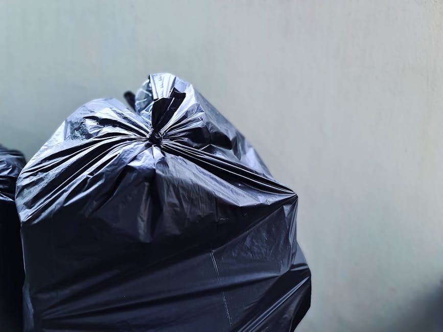 A close-up image of a white rectangular sign mounted on a brick wall. The sign displays the message 'NO DUMPING OF RUBBISH' in black, bold, uppercase letters, with the words slightly offset or misalig